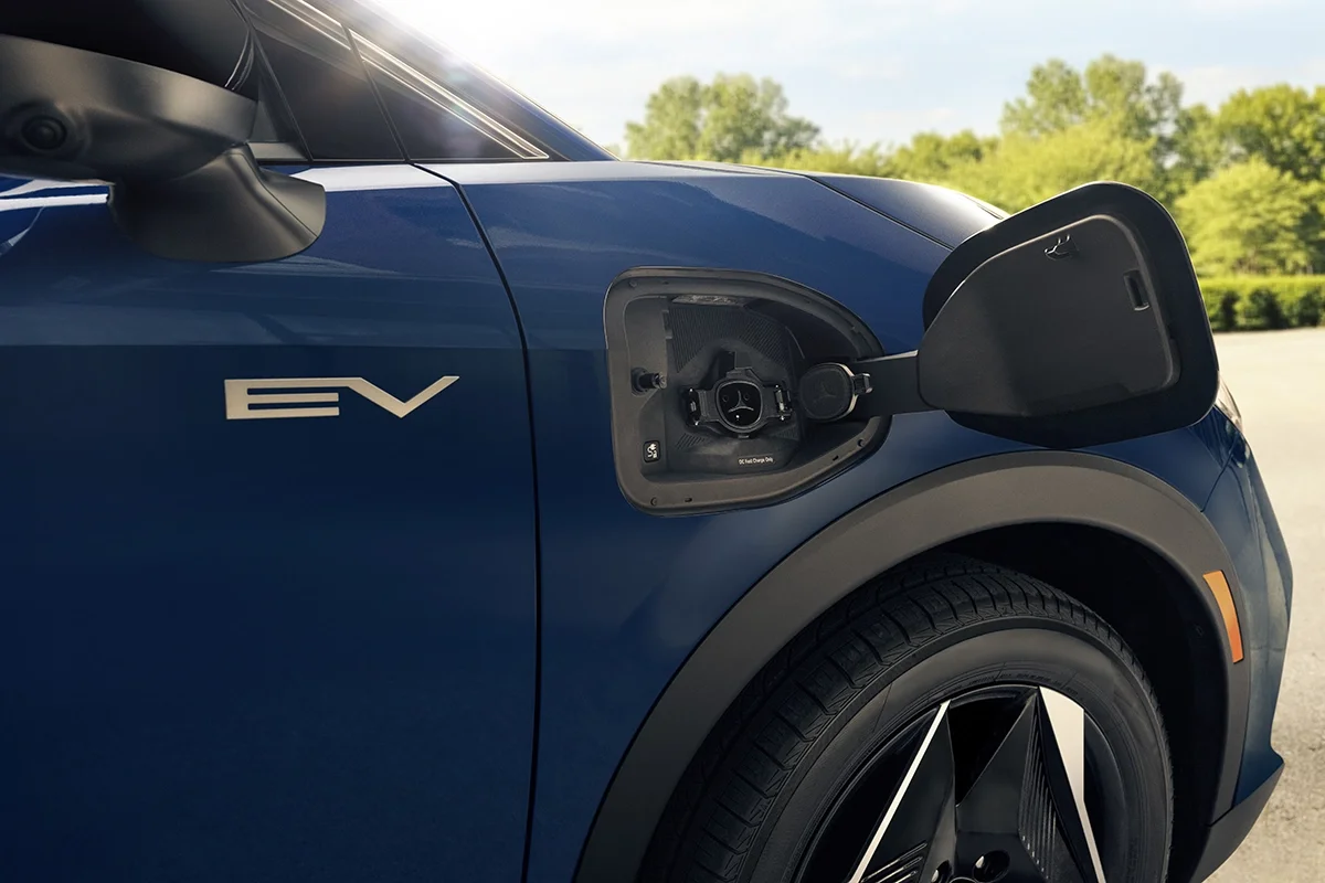 Man's hand plugging in the 2027 Eclipse Sportback EV on the drive side